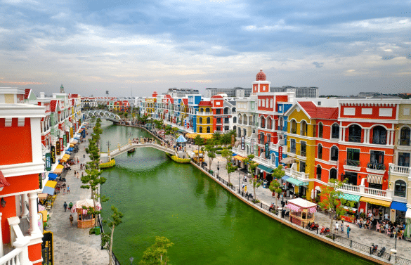 Quartier touristique animé à Phú Quốc avec bâtiments colorés, canal et ponts piétons.