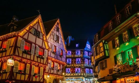 Maisons à colombages illuminées sur le marché de Noël de Colmar en Alsace, France.
