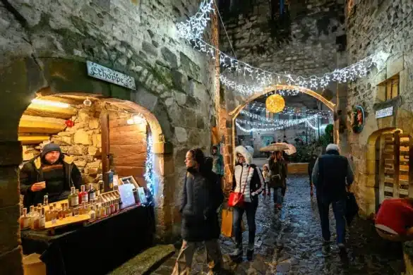 Ruelle médiévale illuminée avec stands d’artisanat au marché de Noël de La Sauvetat dans le Puy-de-Dôme
