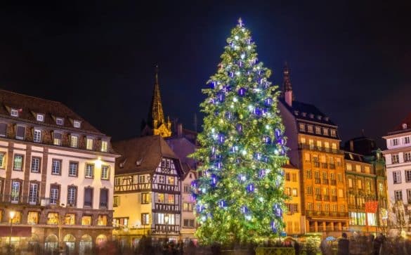 Marché de Noël de Strasbourg sur la place Kléber avec un grand sapin illuminé et les maisons alsaciennes traditionnelles en arrière-plan.