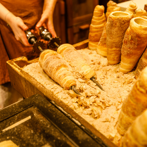 Trdelník, pâtisserie traditionnelle tchèque caramélisée cuite à la broche, servie sur les marchés de Noël de Prague.