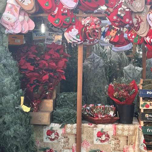 Stand décoré avec fleurs de Noël, couronnes et articles artisanaux sur le marché de Noël de Barcelone, en Espagne.