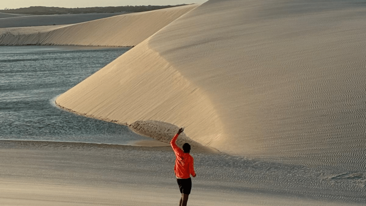 Voyageuse face aux dunes de sable et à une lagune, paysage naturel spectaculaire et inspirant