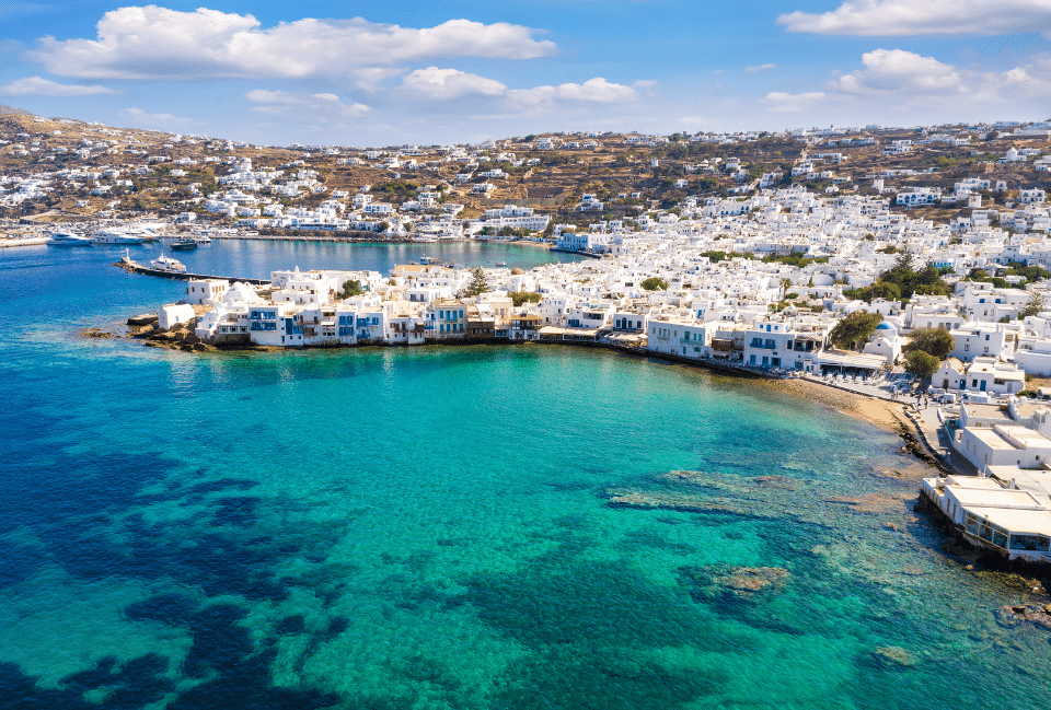 Cyclades en Grèce : îles paradisiaques à découvrir en mai et juin Vue aérienne d’une île des Cyclades avec maisons blanches et mer turquoise en Grèce