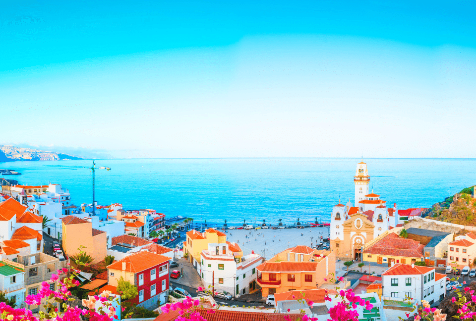 Tenerife aux Canaries : village coloré face à l’océan Vue panoramique d’un village de Tenerife avec église, maisons colorées et océan Atlantique