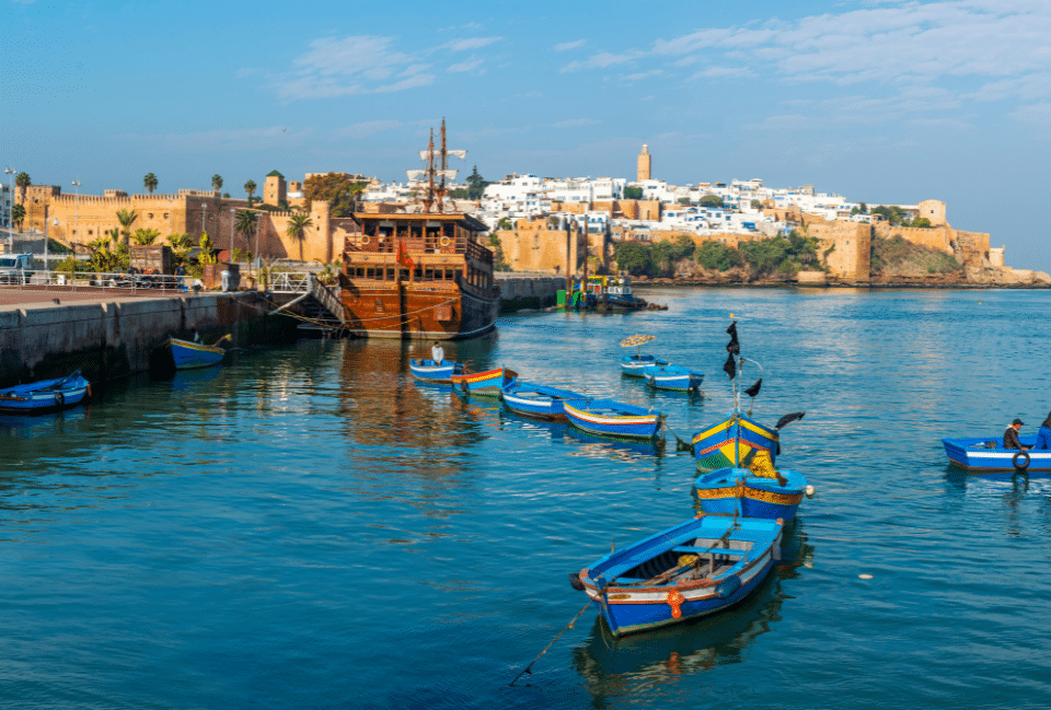 Port de Rabat au Maroc : bateaux colorés et médina face à l’océan Barques de pêche colorées dans le port de Rabat avec la médina en arrière-plan au Maroc