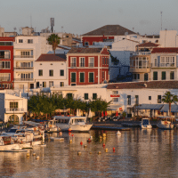 Port de Minorque : village méditerranéen aux Baléares Port de Minorque avec bateaux et maisons colorées au bord de l’eau