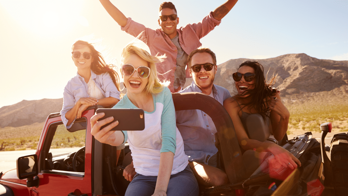 Groupe d’amis en road trip prenant un selfie dans une voiture lors d’un week-end entre amis