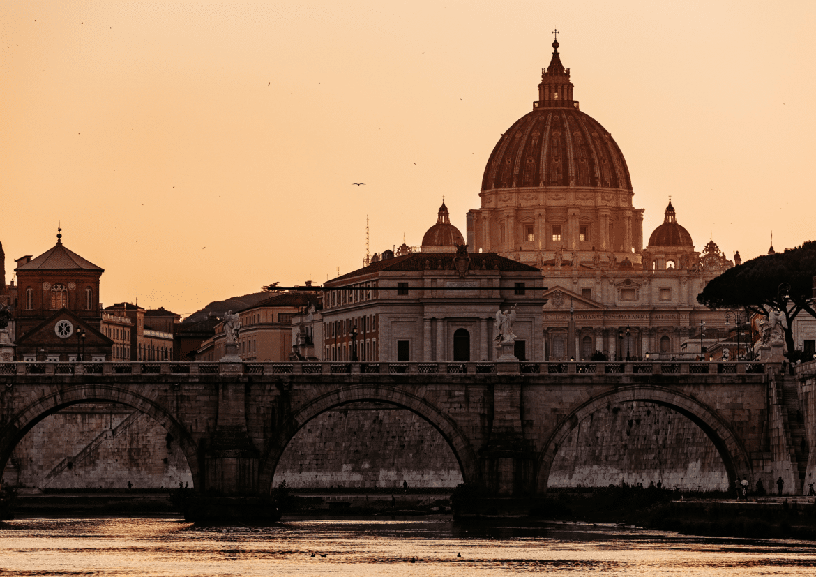 Rome en Italie : coucher de soleil sur la basilique Saint-Pierre et le Tibre Vue de Rome au coucher de soleil avec la basilique Saint-Pierre, un pont sur le Tibre et une lumière dorée emblématique