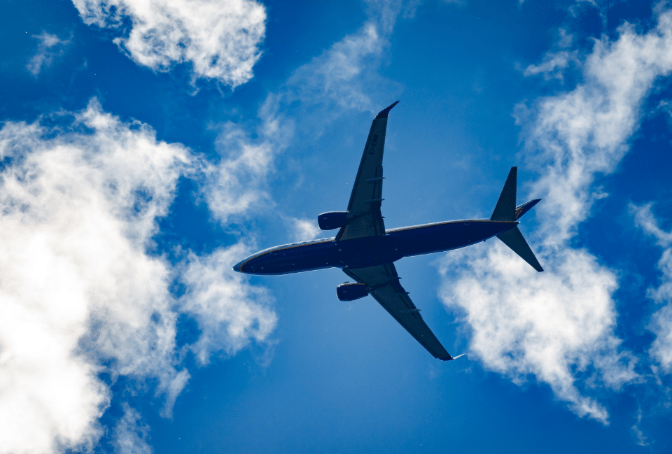 Avion de ligne en vol dans un ciel bleu illustrant les conseils pour réserver un billet d'avion et voyager sereinement.